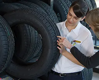 Les Schwab employee showing a tire to a customer